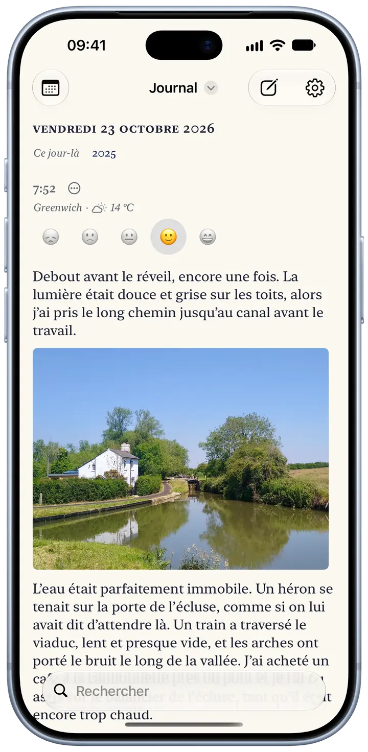 La page du jour dans Bifolio sur un iPhone, vendredi 23 octobre 2026 : une entrée de 7 h 52 à Greenwich, 14 °C et partiellement nuageux, un sourire choisi pour l’humeur, un court paragraphe sur une promenade matinale et la photo d’une maisonnette blanche au bord d’une écluse.