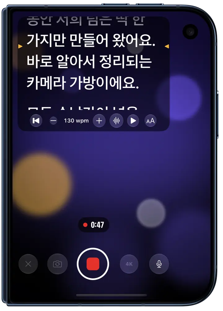 접은 iPhone Duo의 외부 디스플레이에서 녹화 중인 Eyeline: 화면 위쪽 패널에서 대본이 스크롤되고 읽을 줄 양옆에 호박색 표시가 있으며, 그 아래로 녹화 타이머와 녹화 버튼이 보여요.