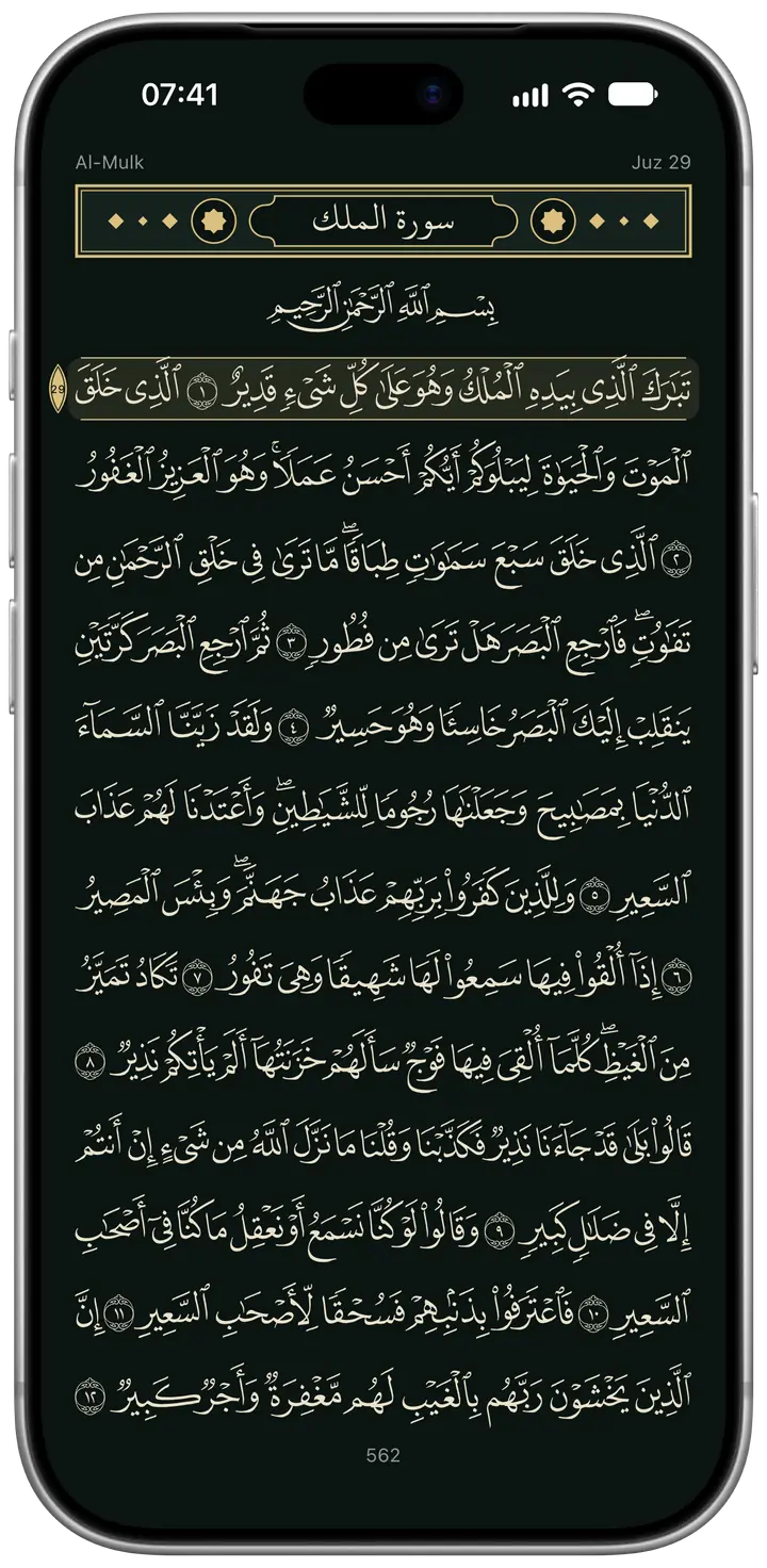 The night page: page 562, the opening of Surah Al-Mulk, in ivory-gold text on a deep green-black page.