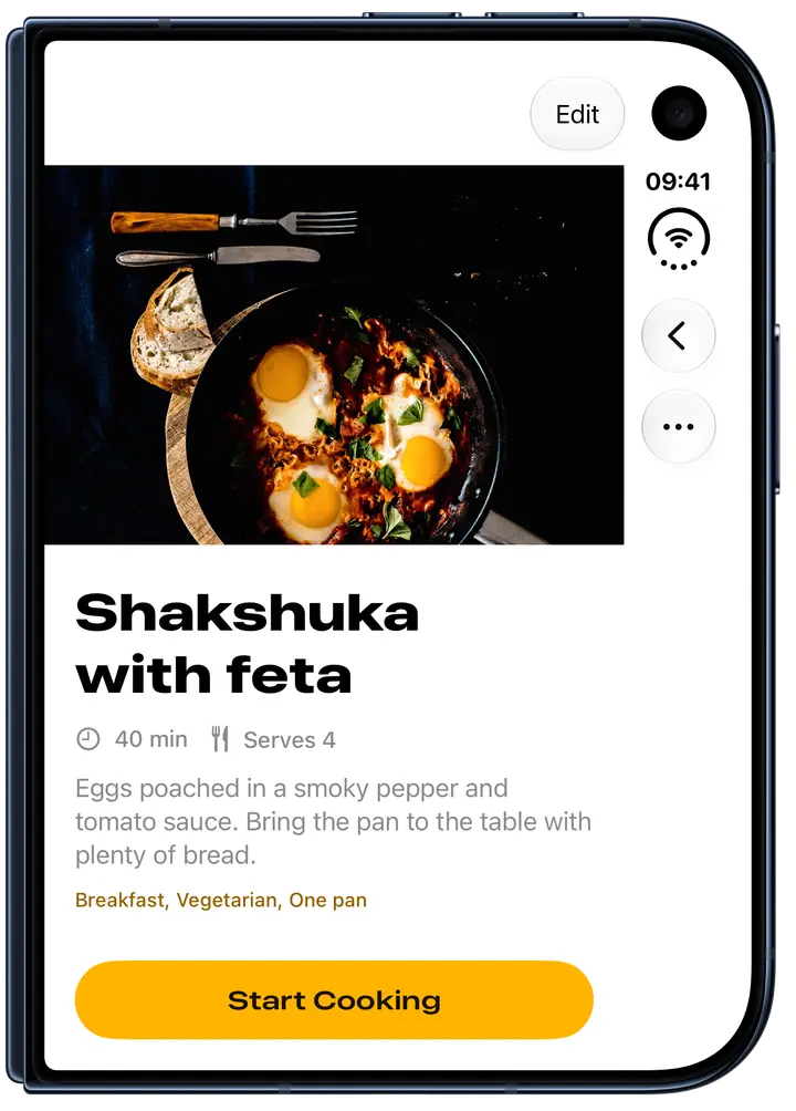 Spread on the cover display of a closed iPhone Duo, showing the shakshuka recipe with its photo, cooking time, servings and Start Cooking button.
