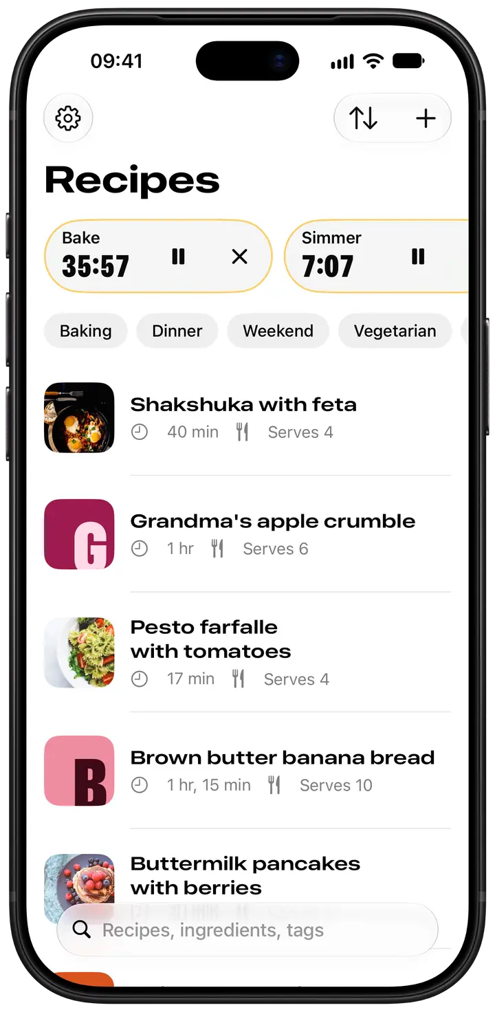 Spread’s recipe library on iPhone: Bake and Simmer timers running at the top, tags to filter by, and recipes shown with their photos or a pantry-coloured initial.